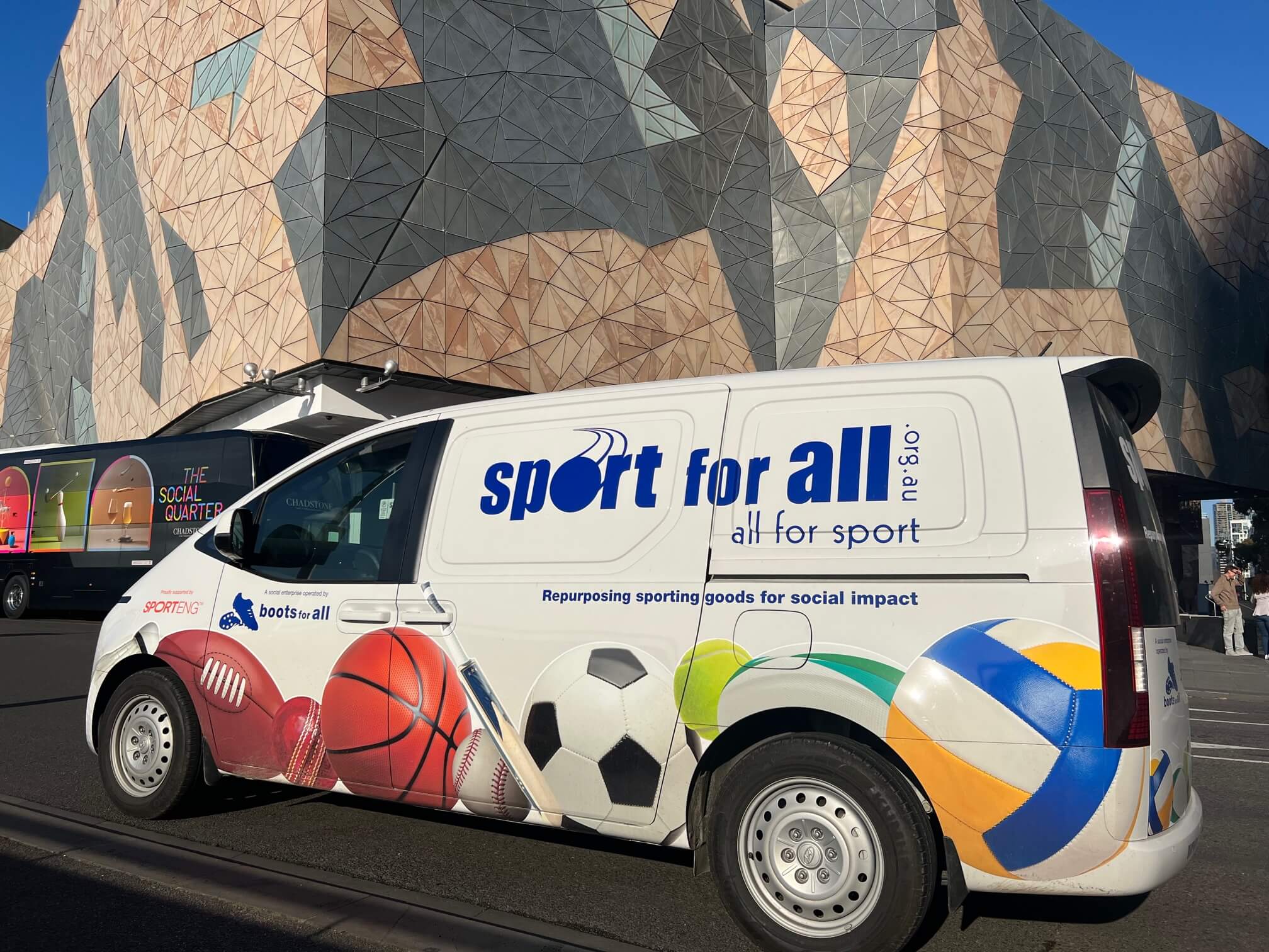 Van with sports ball images on it parked in front of an art building