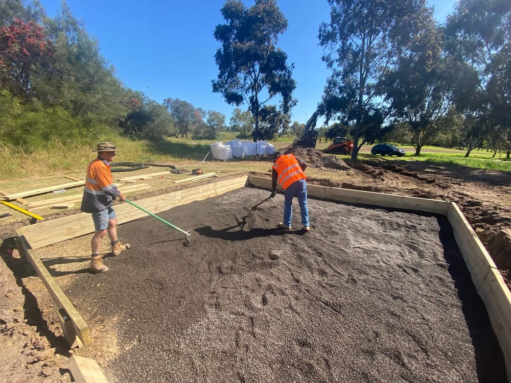 Two people framing a plot of sand 
